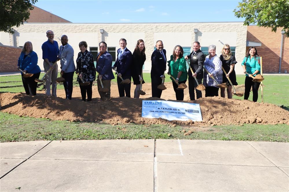  Adults with shovels at a groundbreaking ceremony.