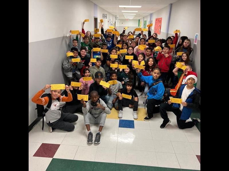 students in hallway holding up their Gattiland passes