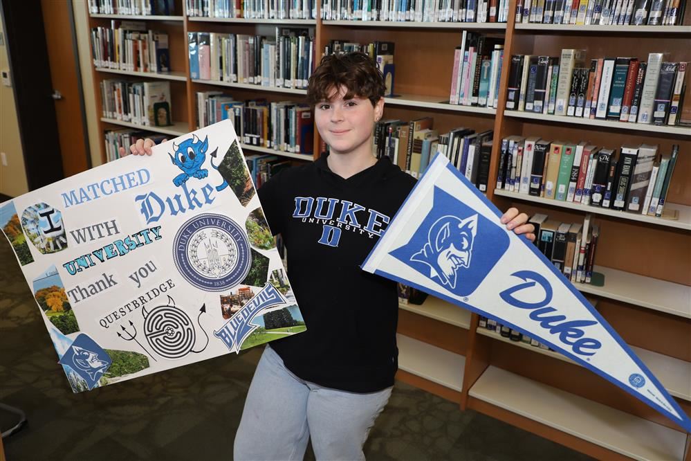  Student holding college sign and banner
